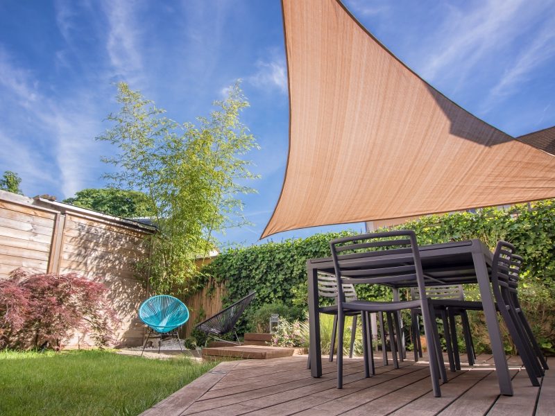 Modern house terrace in summer with table and shade sail